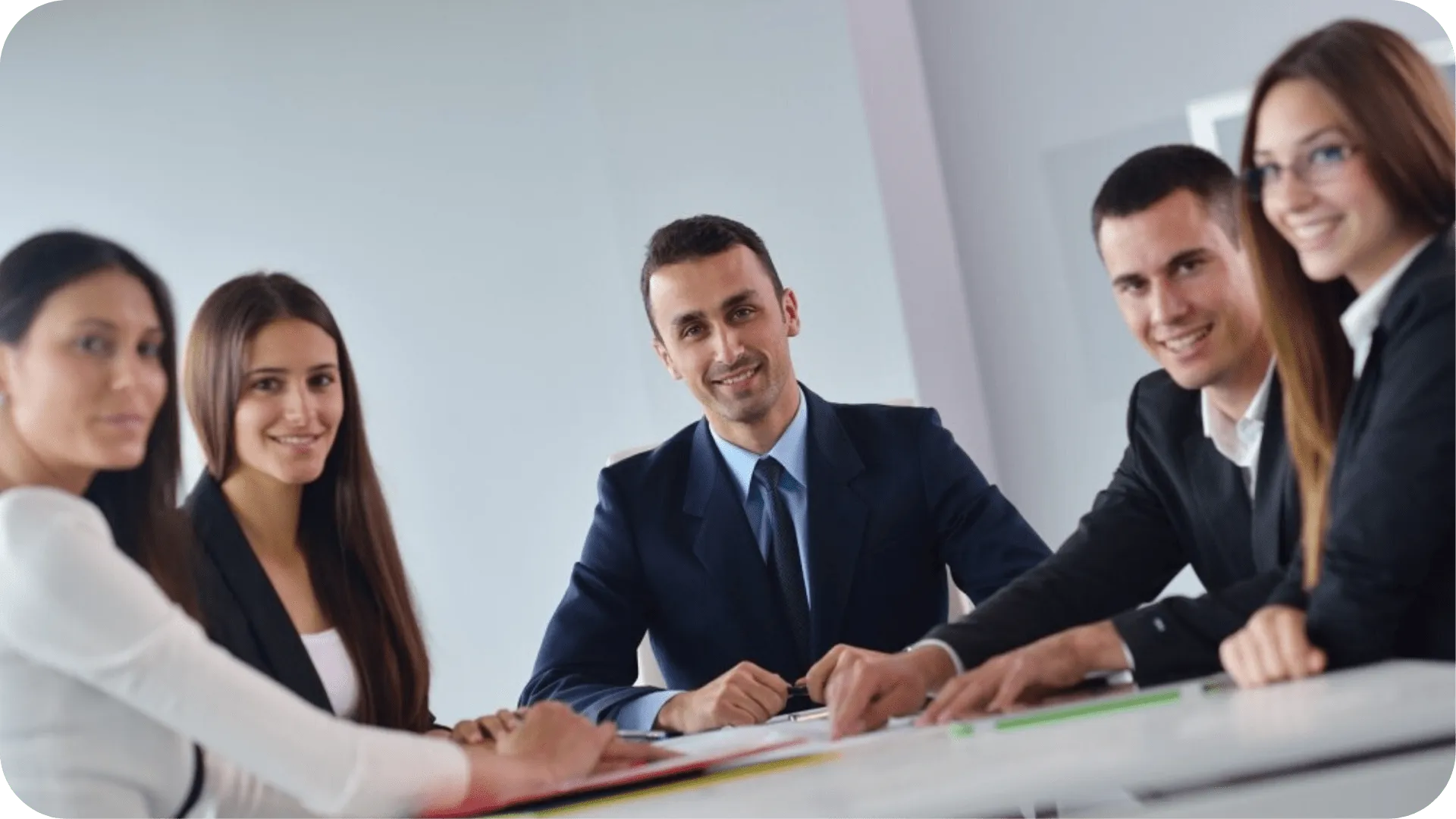 A group of happy people around a table in a workplace.